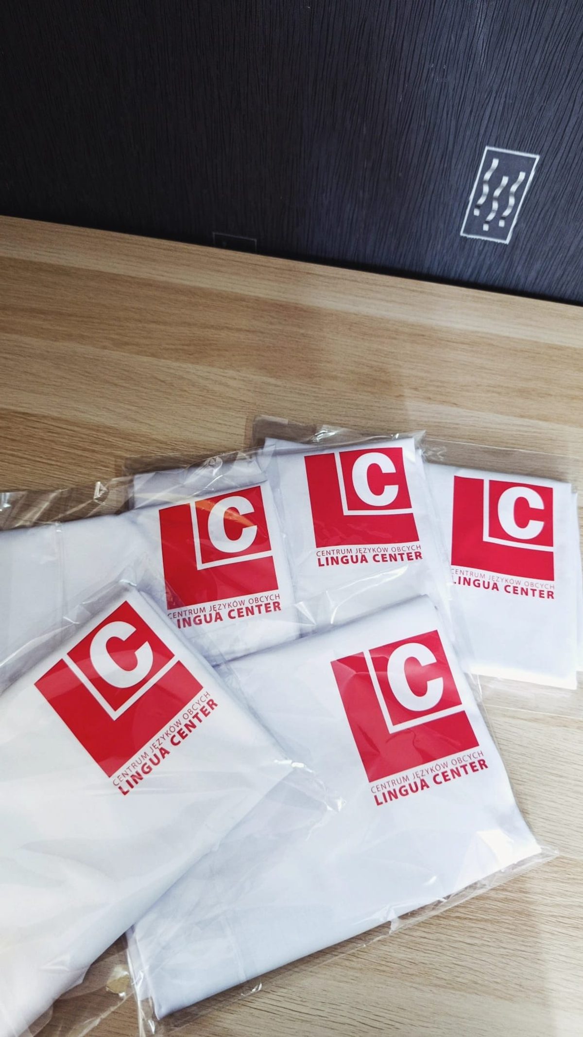 Białe koszulki z nadrukiem logo Lingua Center